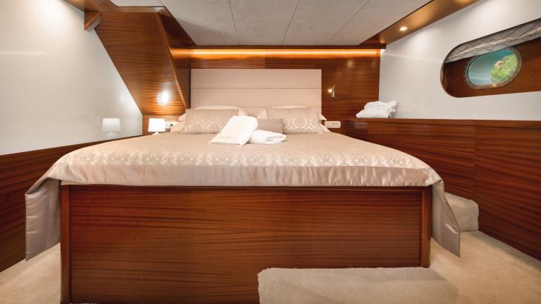 Ein elegant dekoriertes Doppelbett mit verschiedenen Kissen und dezente Dekoration.